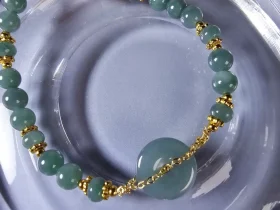 AB-PER-02-06 Handgefertigtes Jade Armband aus blau-grünen Jade-Perlen mit goldenen Trennperlen und einem runden Jade-Anhänger (Ping-An-Knopf). Eleganter Schmuck mit traditioneller chinesischer Symbolik.