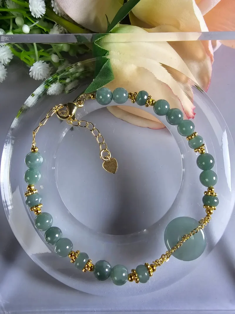 AB-PER-02-07 Handgefertigtes Jade Armband aus blau-grünen Jade-Perlen mit goldenen Trennperlen und einem runden Jade-Anhänger (Ping-An-Knopf). Eleganter Schmuck mit traditioneller chinesischer Symbolik.