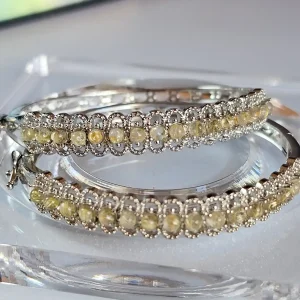 Ein Paar elegante Armbänder aus Weißkupfer, besetzt mit funkelnden goldfarbenen Rutilquarzen (Goldhaarstein)