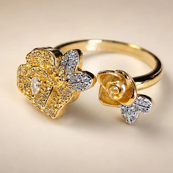 DR-TDG-05-1 Nahaufnahme einer goldfarbenen Damenring. Der Set zeigt zwei stilisierte Rosenblüten: Eine Blüte ist glatt und poliert, die andere ist dicht mit kleinen, funkelnden Kristallen (Pavé-Optik) besetzt und hat einen größeren Kristall in der Mitte.