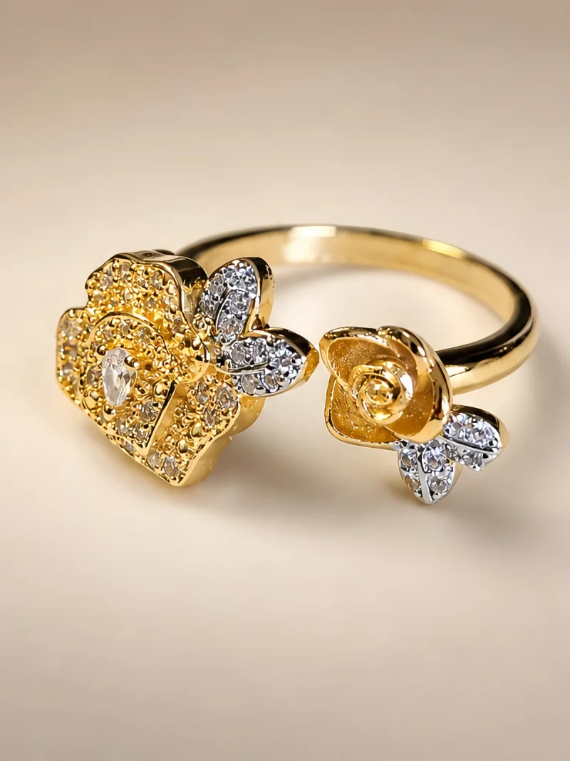 DR-TDG-05-1 Nahaufnahme einer goldfarbenen Damenring. Der Set zeigt zwei stilisierte Rosenblüten: Eine Blüte ist glatt und poliert, die andere ist dicht mit kleinen, funkelnden Kristallen (Pavé-Optik) besetzt und hat einen größeren Kristall in der Mitte.