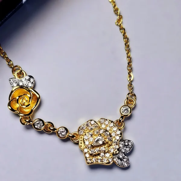 Luxuriöse Rosengold-Halskette mit Kristallbesatz – Filigranes Doppel-Blüten Design Eine zarte zweifarbige Halskette mit einem Anhänger aus zwei Rosen: eine ist eine dreidimensionale goldene Rose, die andere eine silberne Rose, die mit funkelnden Zirkonia-Steinen besetzt ist.
