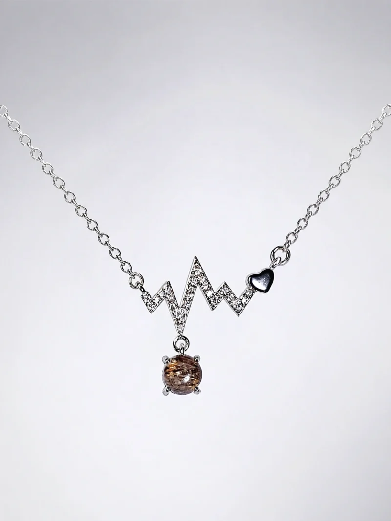Elegante Modeschmuck Halskette mit einem Zickzack-Anhänger, funkelnden Zirkonia, einem herzförmigen Detail und einem braunen Rutilquarz-Anhänger.