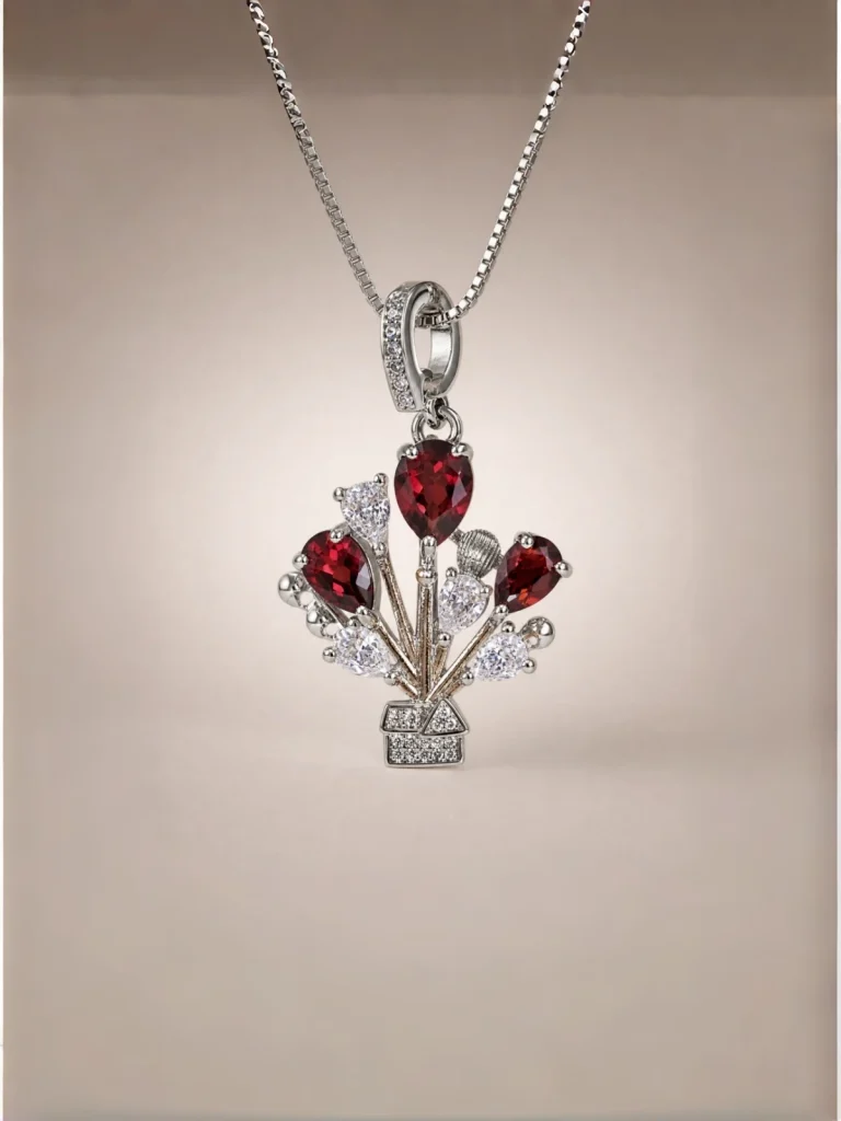 Damen Halskette mit rotem Granat Naturstein und Zirkonia in Luftballon-Design ein Modeschmuck Halskette mit roter Granat Naturstein Anhänger- Luftballon-Design, vor einer weißen Hintergrund.