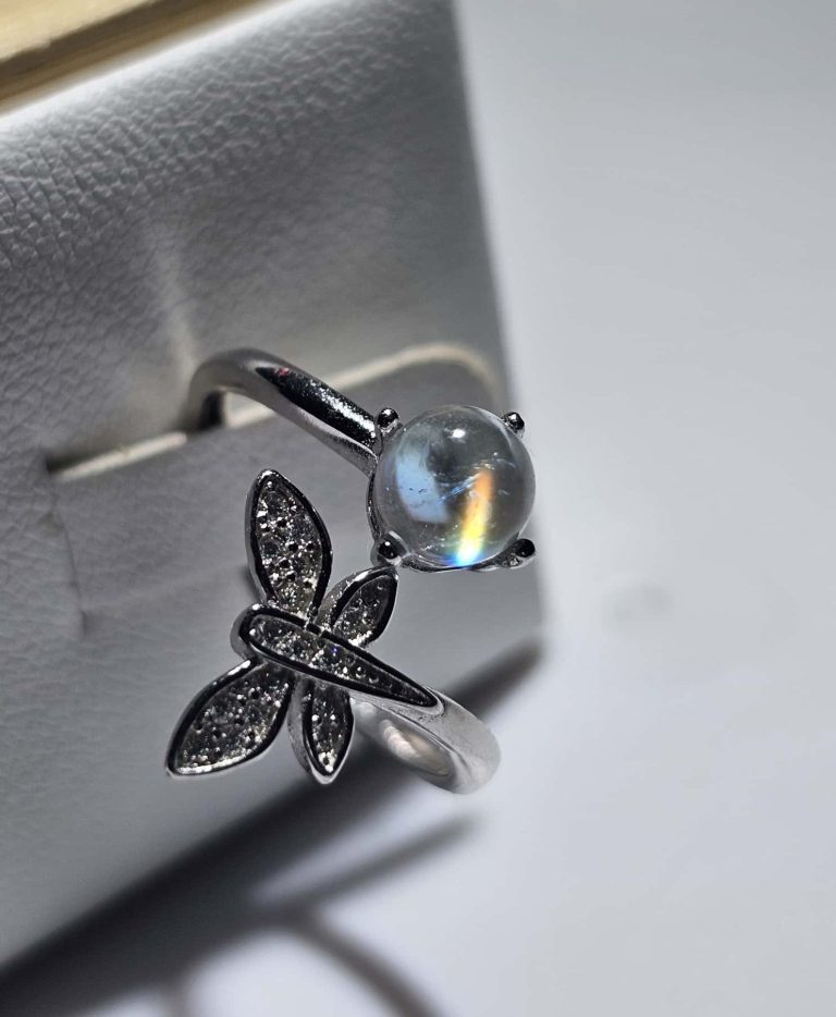 Damenring 925er Silber Mondstein Regenbogen- Schmetterling Design Offener Mondstein Ring aus 925er Sterlingsilber mit einem leuchtenden madagassischen Mondstein, der ein faszinierendes Regenbogen-Feuer zeigt, verziert mit einem funkelnden Schmetterling aus Zirkonia.