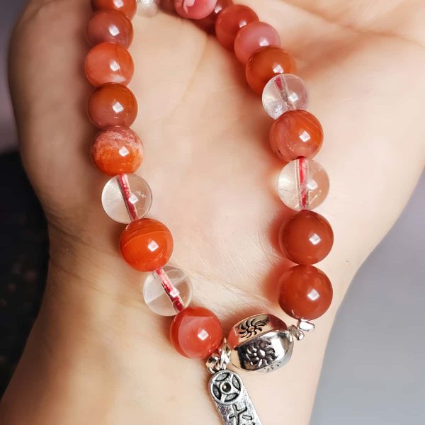 AB-ACT-02 Damenarmband aus rotem Achat Kugeln Bergkristall fein poliert versiberten Details mit chinesischen Schriftzeichen in der offenen Hand gezeigt. Ansicht der versilberten Details mit chinesischen Schriftzeichen.