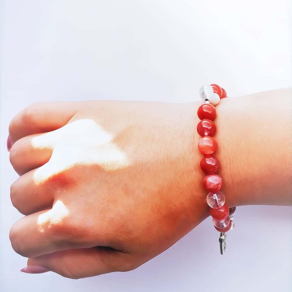 AB-ACT-03 Damenarmband aus rotem Achat Kugeln Bergkristall fein poliert versiberten Detals mit chinesischen Schriftzeichen getragen am Handgelenk bei Tageslicht