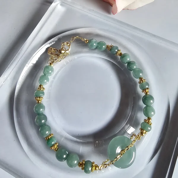 Blauwasser Jade Armband Naturstein -PER-02-03 Handgefertigtes Jade Armband aus blau-grünen Jade-Perlen mit goldenen Trennperlen und einem runden Jade-Anhänger (Ping-An-Knopf). Eleganter Schmuck mit traditioneller chinesischer Symbolik.