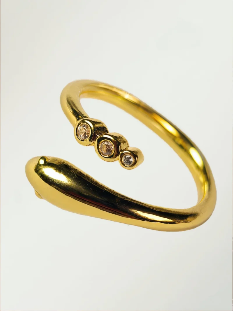 Goldener Ring im Schlangen-Design mit drei runden Zirkonia-Steinen auf weißem Hintergrund.