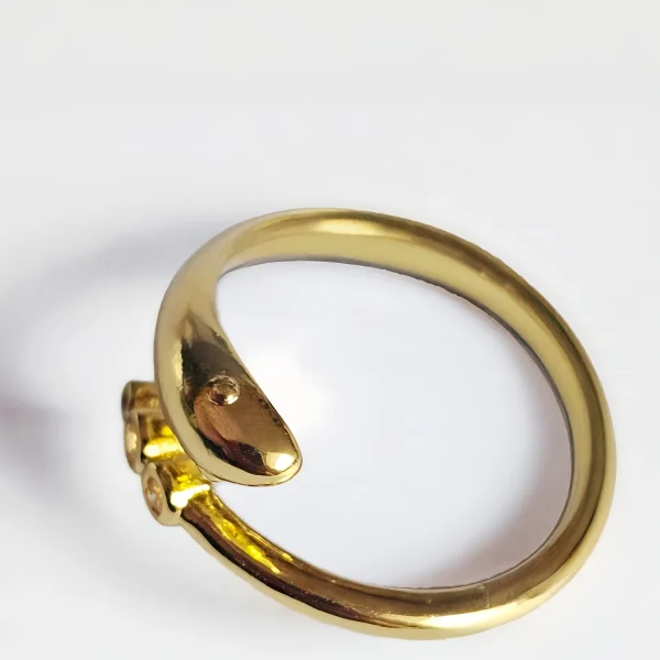 Goldener Ring im Schlangen-Design mit drei runden Zirkonia-Steinen auf weißem Hintergrund.