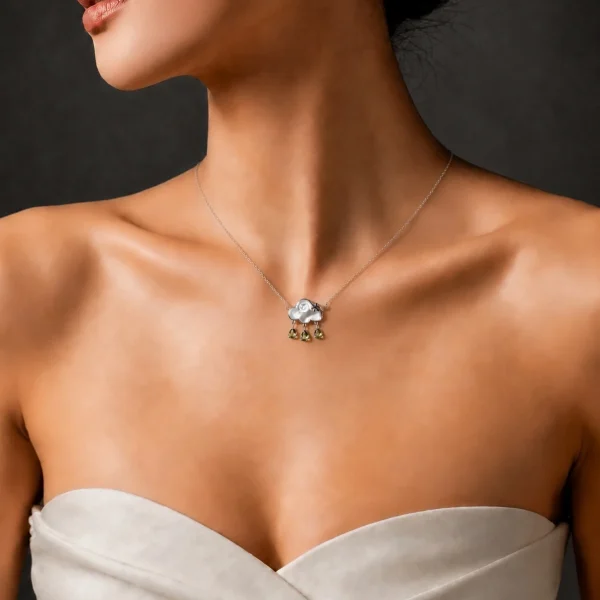 HK-SIL-03-7 Elegante Wolken-Halskette aus S925 Sterling Silber mit einer Wolke aus echtem Perlmutt und drei Peridot-Tropfen, getragen von einem Model zu einem schulterfreien cremefarbenen Oberteil vor dunklem Hintergrund.