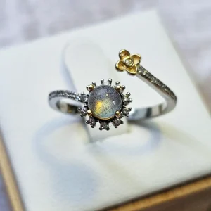 Silberring mit Mondstein in Blumenmotiv Bicolor Design– Offen Damenring Offener Silberring mit rundem, schimmerndem Mondstein, funkelnden Zirkonia und goldfarbenem Blumen-Detail.