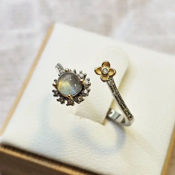 DR-SIL-04-2 Offener Silberring mit rundem, schimmerndem Mondstein, funkelnden Zirkonia und goldfarbenem Blumen-Detail.