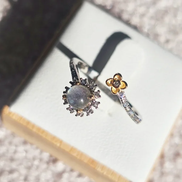 DR-SIL-04-4 Offener Silberring mit rundem, schimmerndem Mondstein, funkelnden Zirkonia und goldfarbenem Blumenmotiv.