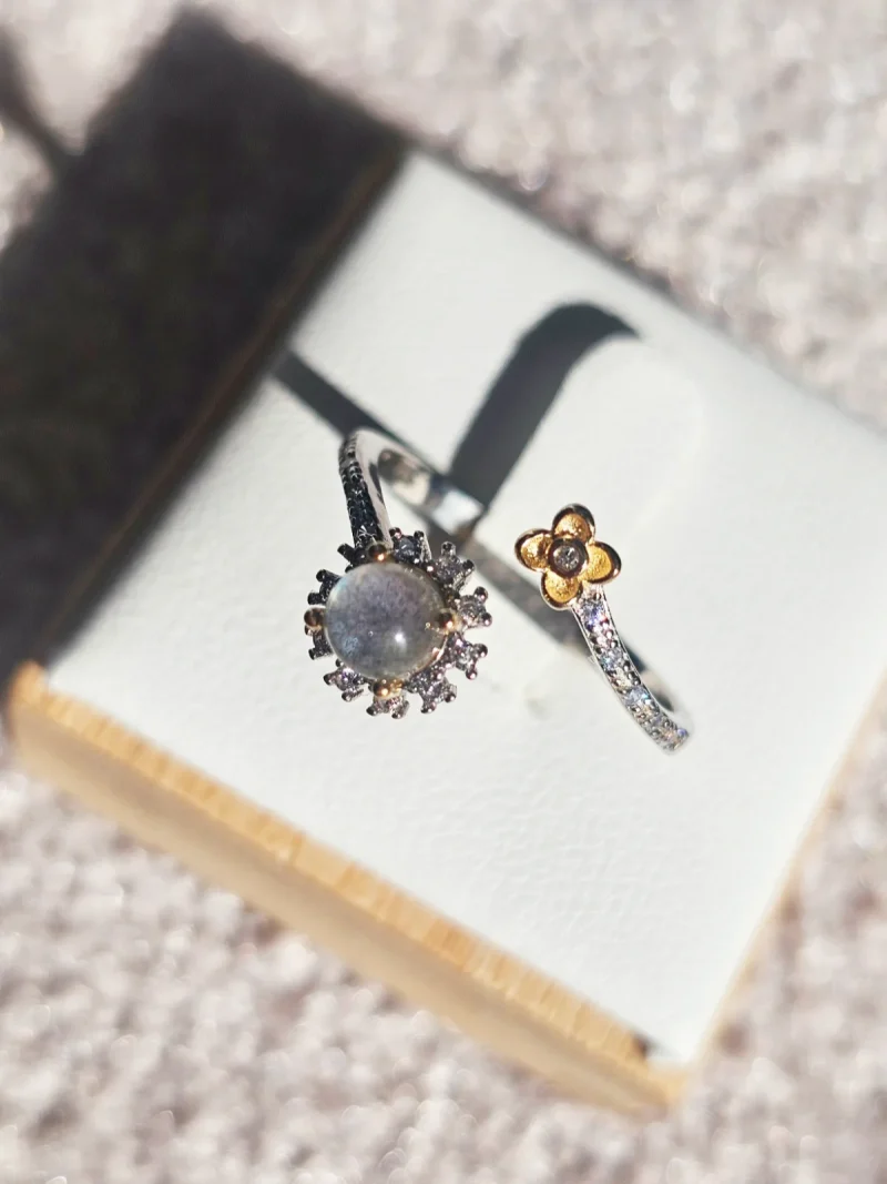 DR-SIL-04-4 Offener Silberring mit rundem, schimmerndem Mondstein, funkelnden Zirkonia und goldfarbenem Blumenmotiv.
