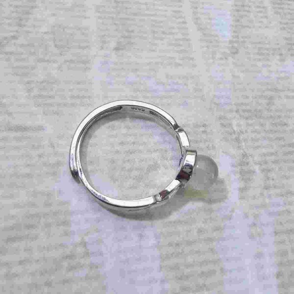 DR-TDS-09-04 Seitenansicht eines silberfarbenen Rings mit ovalem Mondstein und filigranen Zirkonia-Verzierungen an der Ringschiene.
