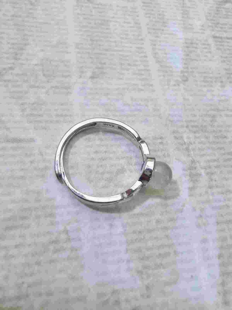 DR-TDS-09-04 Seitenansicht eines silberfarbenen Rings mit ovalem Mondstein und filigranen Zirkonia-Verzierungen an der Ringschiene.